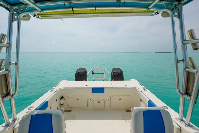 Slide: The Image of 2006 World Cat 250 DC boat on turquoise water, featuring spacious deck and dual engines. - 9