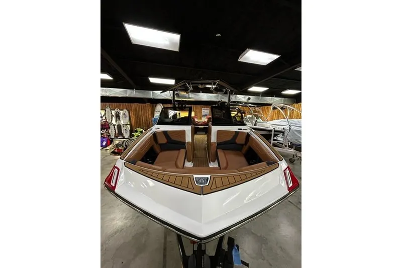 Slide: The Image of 2023 Nautique Super Air Nautique G23 boat in showroom, featuring sleek design and luxurious seating. - 2