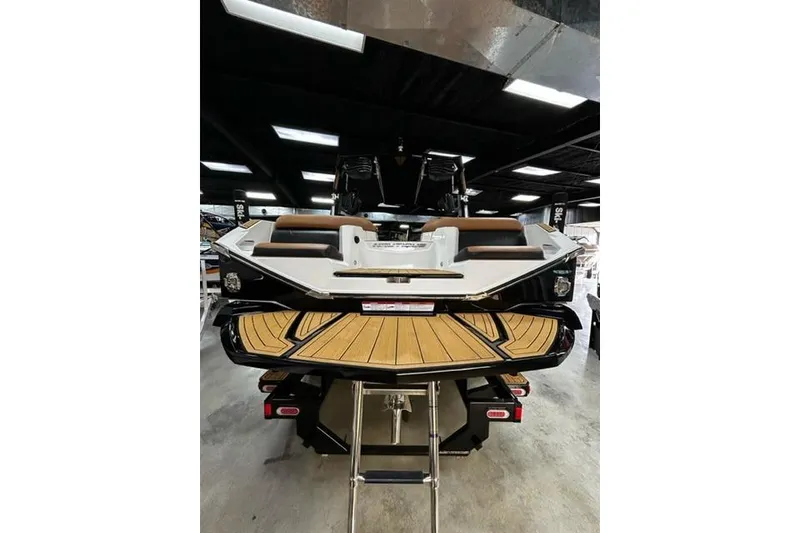 Slide: The Image of 2023 Nautique Super Air Nautique G23 boat, rear view in showroom setting. - 7