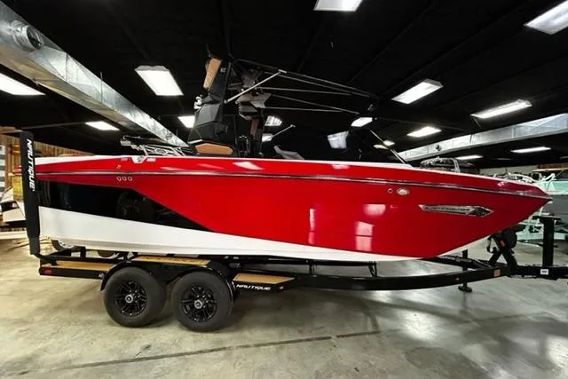 Slide: The Image of 2023 Nautique Super Air Nautique G23 boat in showroom, red and white exterior. - 8