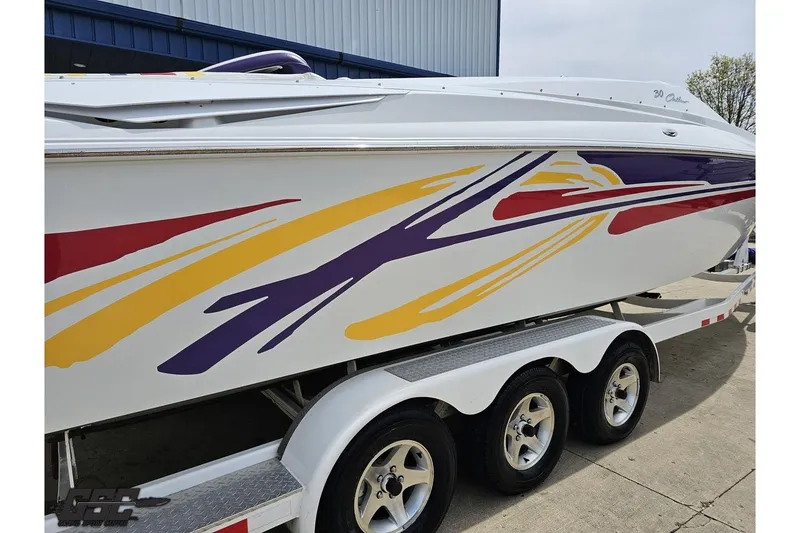 Slide: The Image of 2005 Baja 30 Outlaw boat with colorful graphics on a triple-axle trailer. - 10
