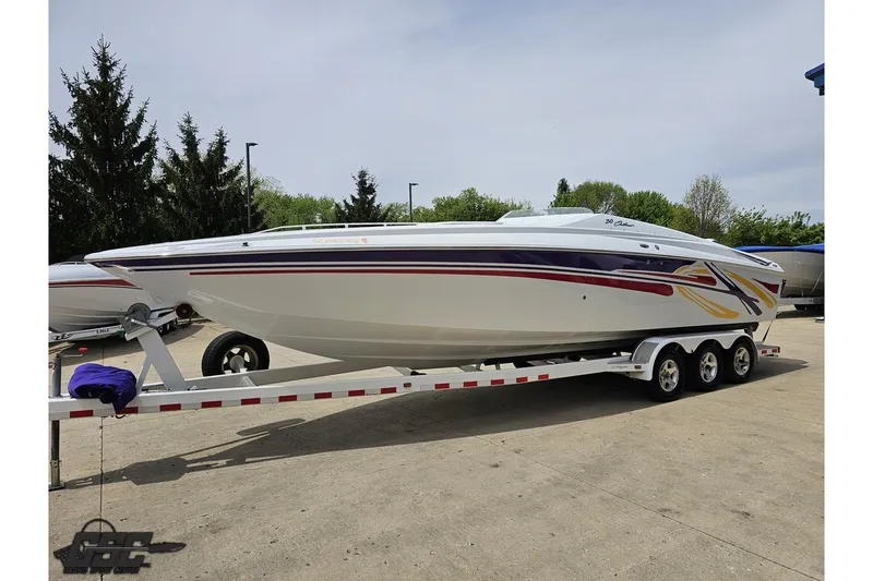 Slide: The Image of 2005 Baja 30 Outlaw speedboat on trailer, featuring vibrant graphics, parked outdoors. - 19