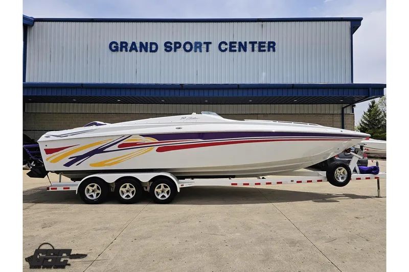 Slide: The Image of 2005 Baja 30 Outlaw boat with colorful graphics on a trailer at Grand Sport Center. - 2