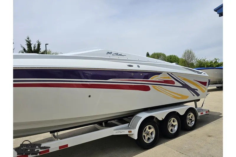 Slide: The Image of 2005 Baja 30 Outlaw boat with colorful graphics on a triple-axle trailer. - 20