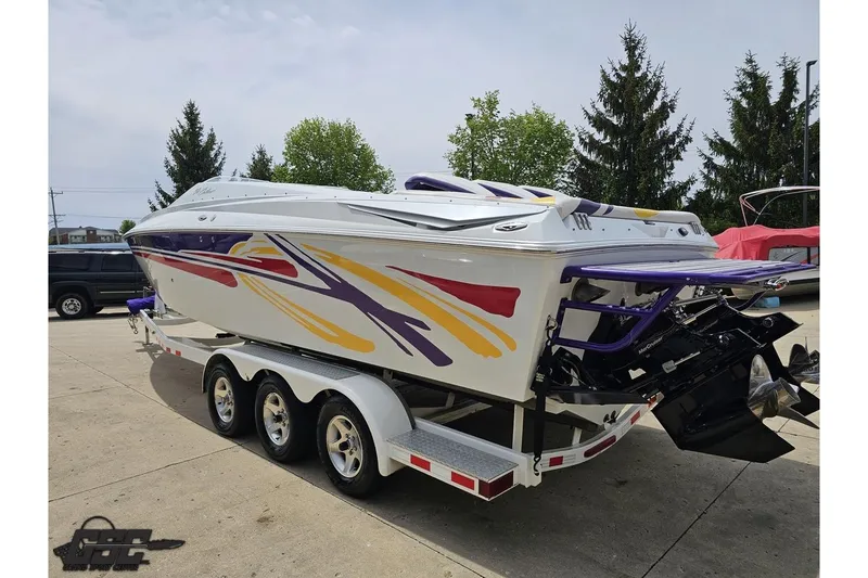 Slide: The Image of 2005 Baja 30 Outlaw boat on trailer with colorful graphics, parked outdoors. - 27