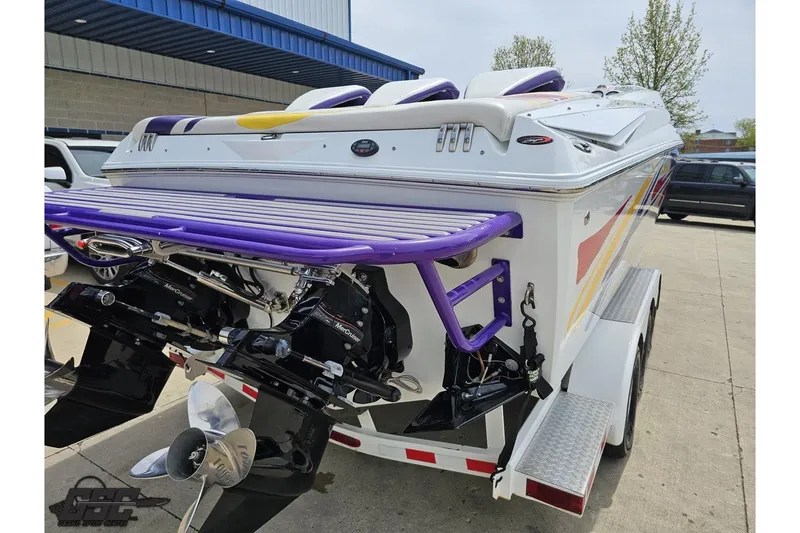 Slide: The Image of 2005 Baja 30 Outlaw boat with vibrant purple accents on a trailer. - 31