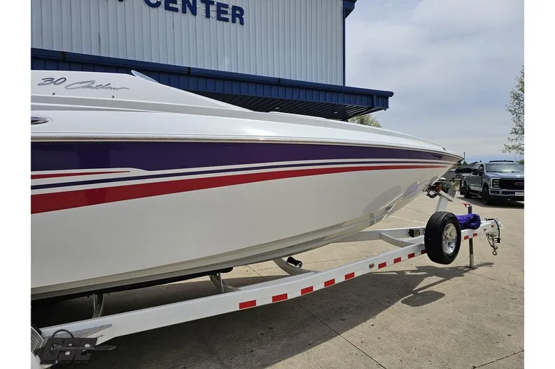 Slide: The Image of 2005 Baja 30 Outlaw boat on trailer, featuring sleek design and vibrant stripes. - 4