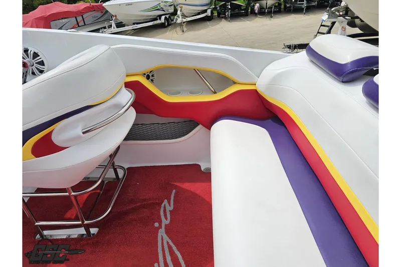 Slide: The Image of Interior of a 2005 Baja 30 Outlaw boat with colorful seating and red carpet. - 48