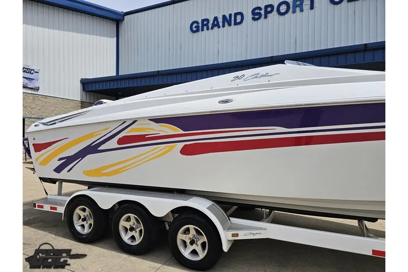 Slide: The Image of 2005 Baja 30 Outlaw boat with colorful graphics on a trailer at Grand Sport Center. - 5
