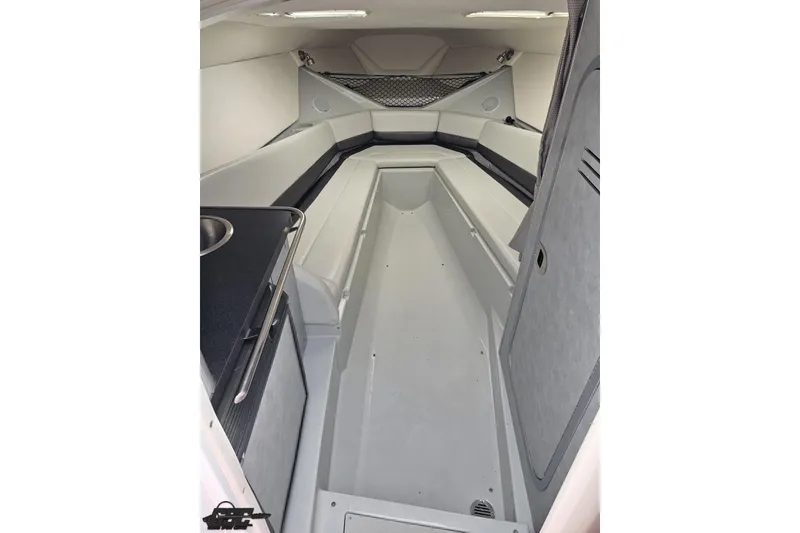 Slide: The Image of Interior cabin of a 2005 Baja 30 Outlaw boat, featuring seating and a compact kitchenette. - 65