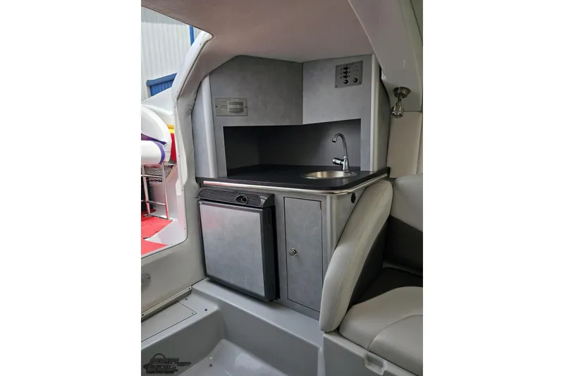 Slide: The Image of 2005 Baja 30 Outlaw boat interior with kitchenette, sink, and mini fridge. - 68