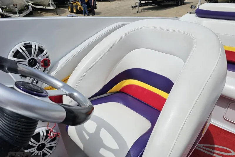 Slide: The Image of Interior of a 2005 Baja 30 Outlaw boat with colorful seating and steering wheel. - 80