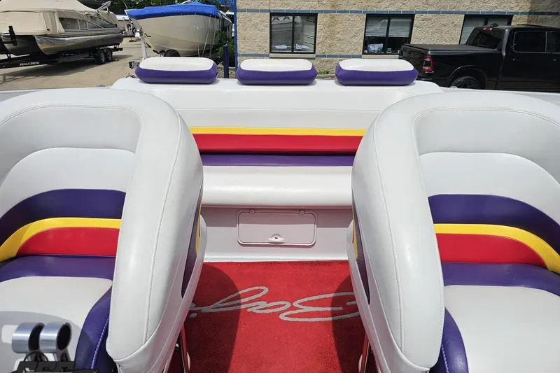 Slide: The Image of Interior of a 2005 Baja 30 Outlaw boat with colorful seating and red carpet. - 81