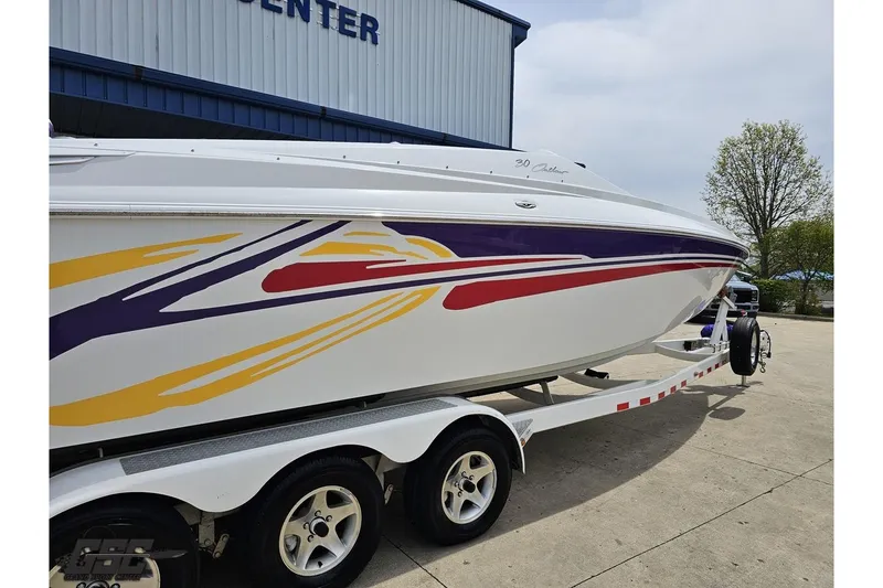 Slide: The Image of 2005 Baja 30 Outlaw boat with colorful graphics on a trailer, parked outside a building. - 9