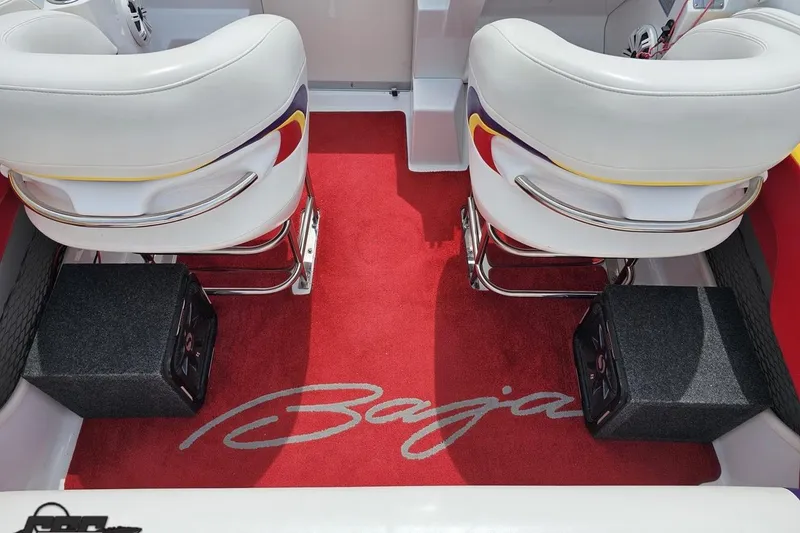 Slide: The Image of Interior of a 2005 Baja 30 Outlaw boat with red carpet and white seats. - 93