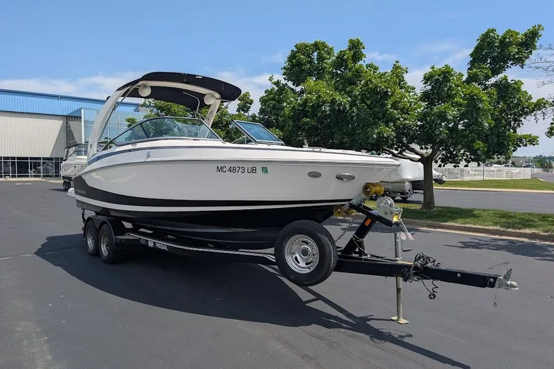 Slide: The Image of 2017 Regal 2500 Bowrider boat on trailer, parked outdoors near trees and building. - 3