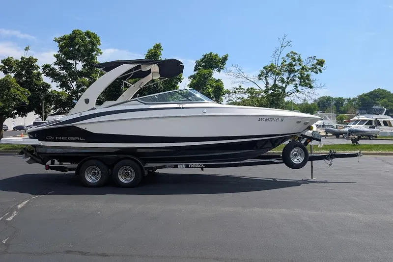 Slide: The Image of 2017 Regal 2500 Bowrider boat on trailer, parked outdoors on a sunny day. - 4