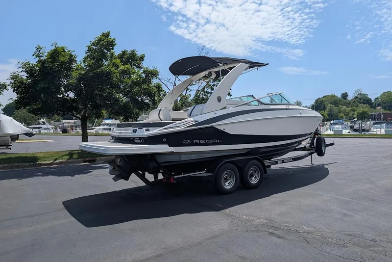Slide: The Image of 2017 Regal 2500 Bowrider boat on trailer, parked outdoors under clear sky. - 5