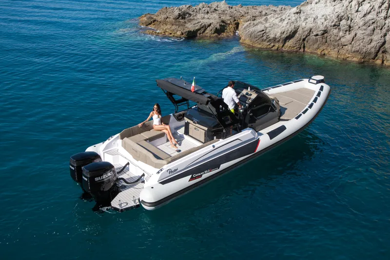 The Image of 2025 Ranieri CAYMAN 35.0 EXECUTIVE luxury boat cruising near rocky shoreline. - 0