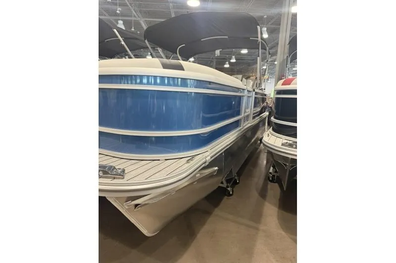 Slide: The Image of 2026 SunCatcher Select 322SL pontoon boat displayed indoors, featuring a sleek blue exterior. - 3