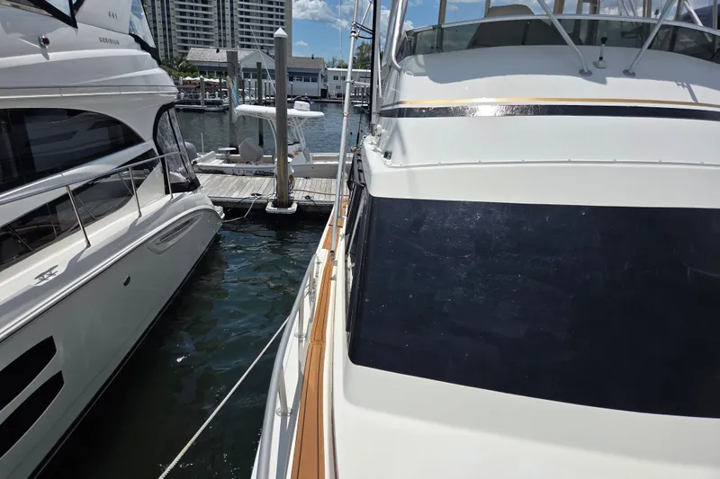 Slide: The Image of Docked Egg Harbor Golden Egg 42 yacht, 1990 model, beside another boat in a marina. - 10