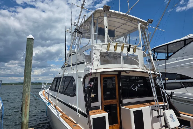 Slide: The Image of 1990 Egg Harbor Golden Egg 42 yacht docked under a partly cloudy sky. - 3