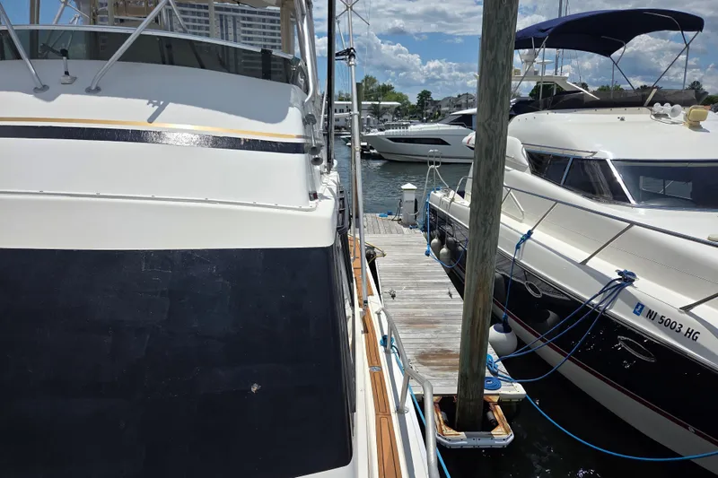 Slide: The Image of Docked Egg Harbor Golden Egg 42 yacht, 1990 model, alongside other boats under a sunny sky. - 9