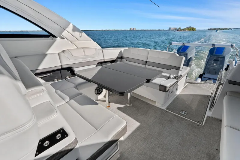 Slide: The Image of 2023 Formula 380 Super Sport Crossover OB interior with luxurious seating and table on open water. - 13