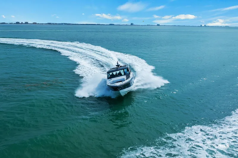 Slide: The Image of 2023 Formula 380 Super Sport Crossover OB cruising on open water, creating a dynamic wake. - 6