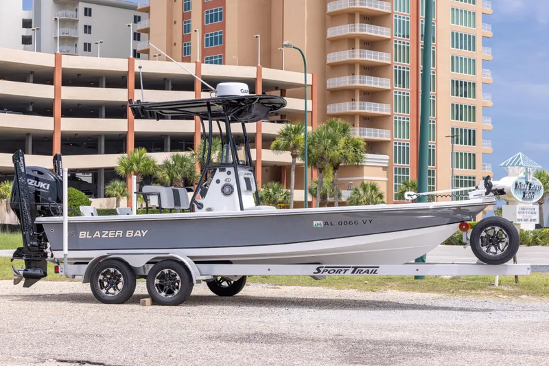The Image of 2023 Blazer Bay 2200 boat on trailer, parked near modern buildings. - 0