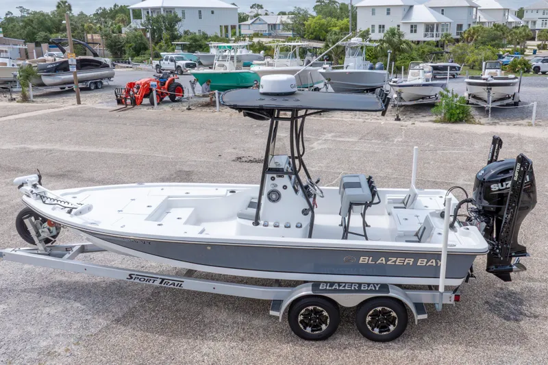 Slide: The Image of 2023 Blazer Bay 2200 boat on trailer in marina setting. - 13
