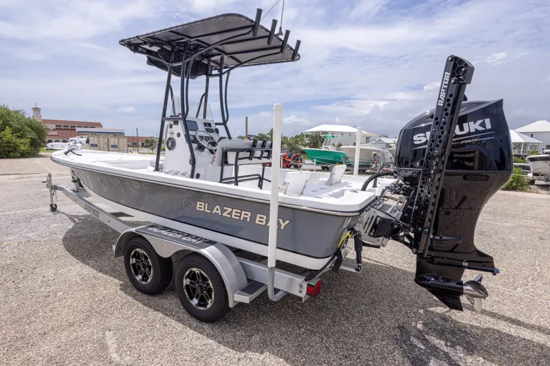 Slide: The Image of 2023 Blazer Bay 2200 boat with Suzuki engine on a trailer, parked outdoors. - 16