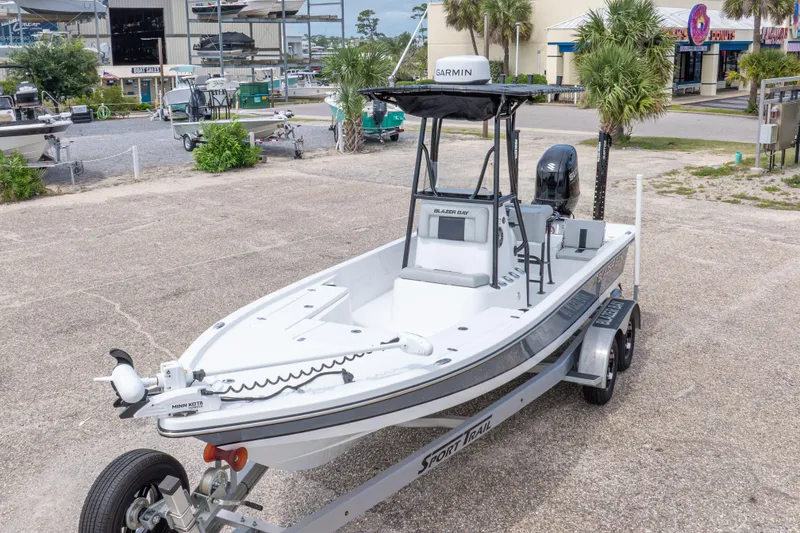 Slide: The Image of 2023 Blazer Bay 2200 boat on trailer in marina setting. - 3