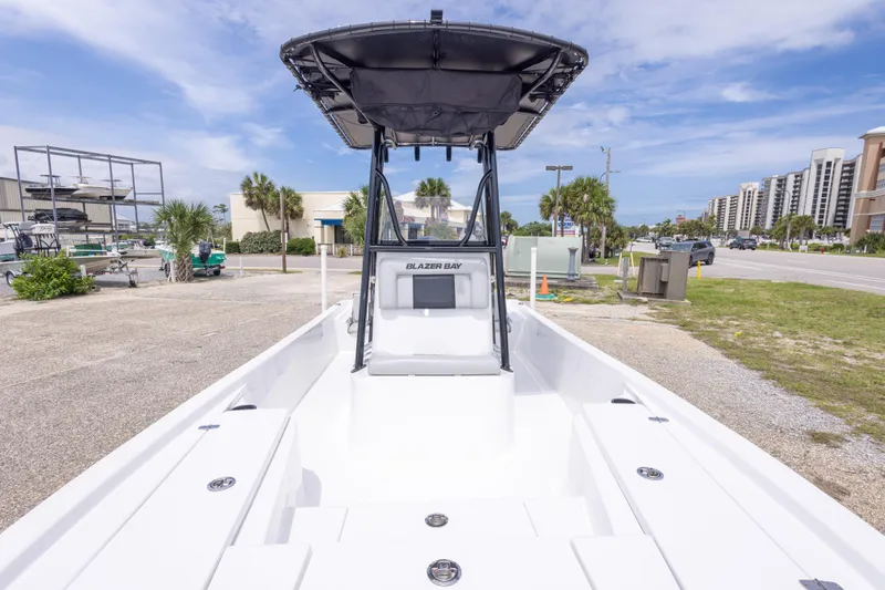 Slide: The Image of 2023 Blazer Bay 2200 boat with T-top, parked near coastal buildings and palm trees. - 34