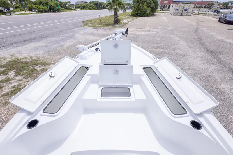 Slide: The Image of 2023 Blazer Bay 2200 boat deck with open storage compartments, parked near a road. - 37