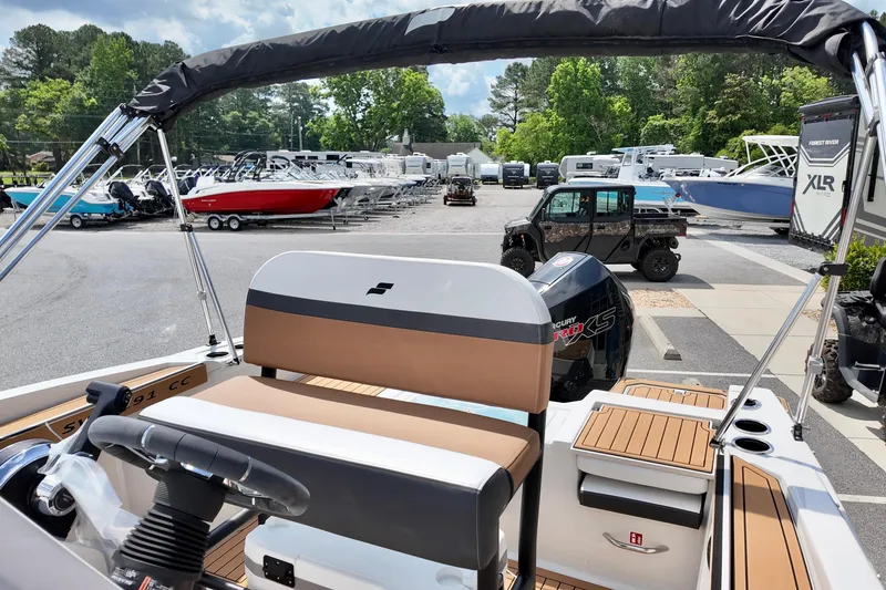 Slide: The Image of 2026 Starcraft SVX 191 OB CC boat interior with steering wheel and seating, parked outdoors. - 10
