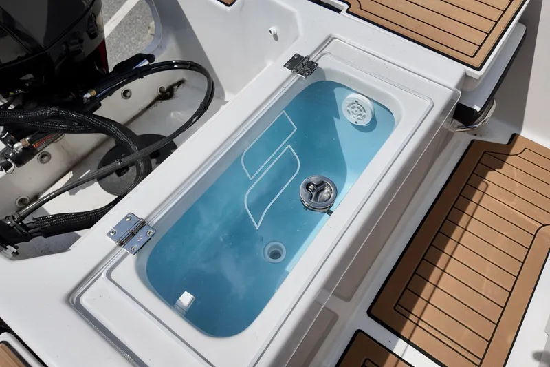 Slide: The Image of Livewell on 2026 Starcraft SVX 191 OB CC boat, featuring teak-style flooring. - 12