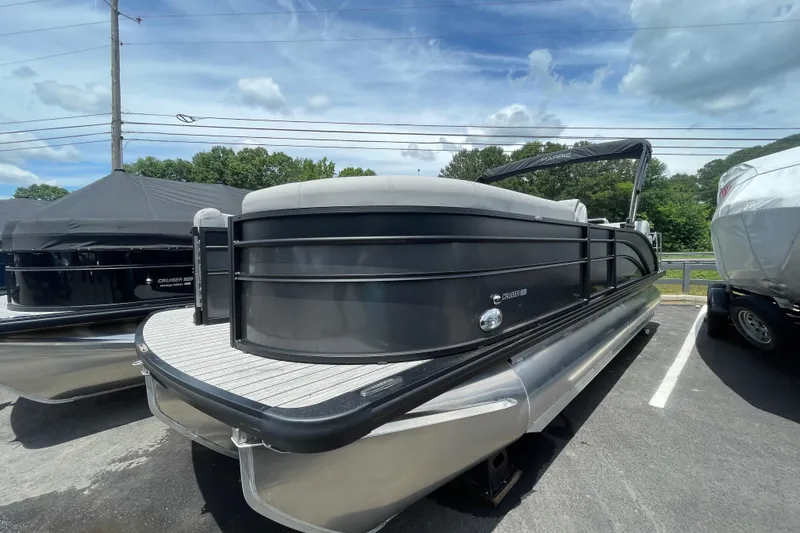 The Image of 2026 Harris Cruiser 230 SLDH pontoon boat parked outdoors under a cloudy sky. - 0