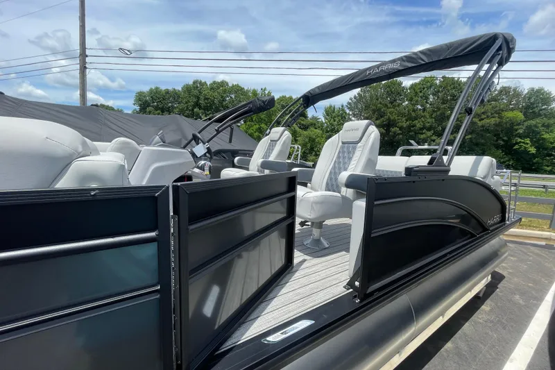Slide: The Image of 2026 Harris Cruiser 230 SLDH pontoon boat with sleek black exterior and plush seating. - 2