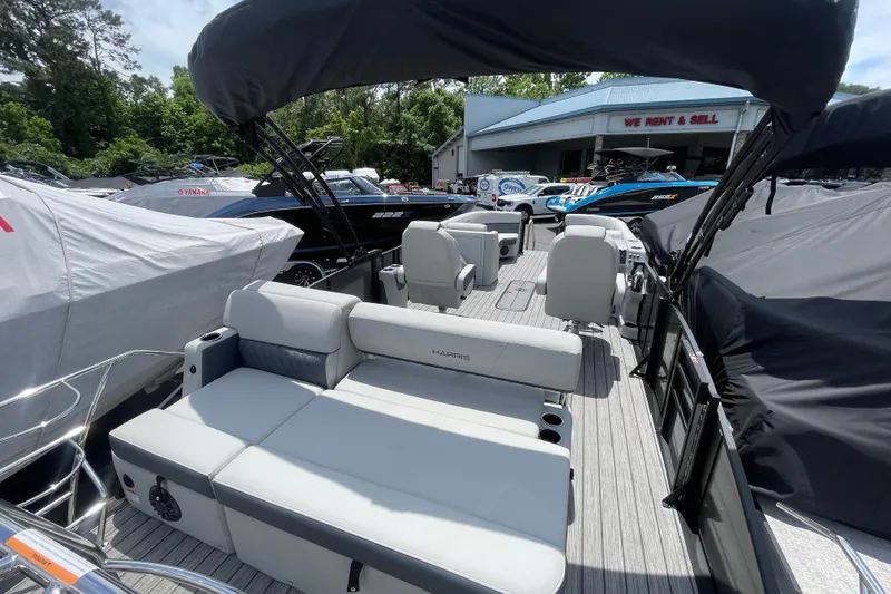 Slide: The Image of 2026 Harris Cruiser 230 SLDH pontoon boat with spacious seating and canopy at a dealership. - 6