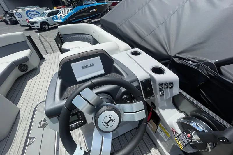 Slide: The Image of 2026 Harris Cruiser 230 SLDH boat interior with steering wheel and Simrad display. - 9