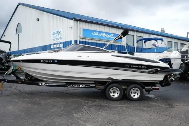 The Image of 2008 Crownline 230 LS boat on trailer, parked outside a marine dealership. - 1