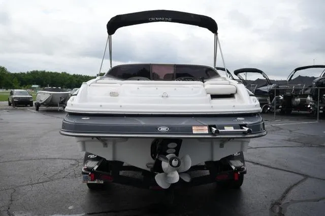 Slide: The Image of 2008 Crownline 230 LS boat, rear view, parked on a trailer in a marina. - 6
