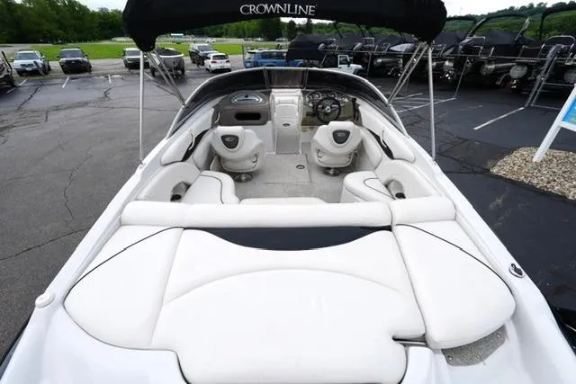 Slide: The Image of 2008 Crownline 230 LS boat with spacious seating and sleek design in a parking lot. - 8