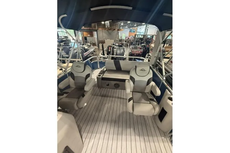Slide: The Image of 2026 SunCatcher Select 322SL boat interior with seating and canopy in showroom. - 10