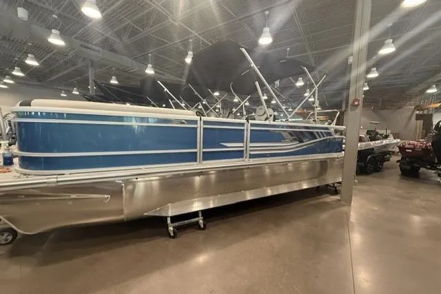 Slide: The Image of 2026 SunCatcher Select 322SL pontoon boat displayed indoors, featuring a sleek blue design. - 3