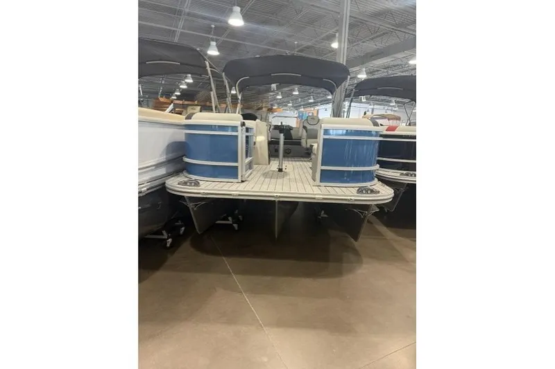 Slide: The Image of 2026 SunCatcher Select 322SL pontoon boat displayed indoors, featuring blue accents. - 5