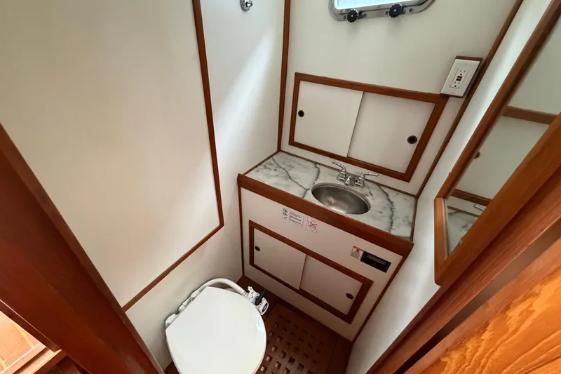 Slide: The Image of Compact bathroom in a 1988 Monk 36 boat, featuring a sink and toilet. - 16