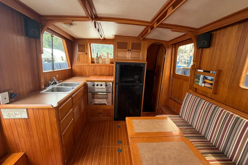 Slide: The Image of Interior of a 1988 Monk 36 boat with wooden cabinetry and striped seating. - 2