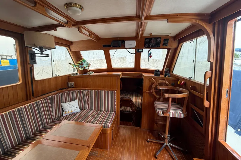 Slide: The Image of Interior of a 1988 Monk 36 boat with wood paneling and striped seating. - 3